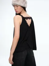 Top de tirantes con diseño a rayas horizontales en blanco y negro, confeccionado con terminaciones de encaje en el escote y en el ruedo.