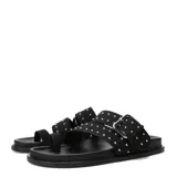 Sandalias Miss Carol modelo Talira de color negro, con diseño plano, tiras dobles decoradas con tachas metálicas plateadas, hebilla ajustable y tira separadora para el dedo.