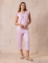 Conjunto de pijama marca René Rofé, compuesto por remera de manga corta con escote en V y botones, y pantalón capri con cintura elastizada, ambos en tejido soft estampado con flores rosas y celestes sobre fondo blanco.