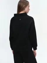 Buzo de cuello polo con escote abotonado, manga larga raglán y puños acanalados. Confeccionado en tejido suave y confortable.