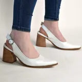 Zapatos stiletto destalonados de cuero color verde menta, con taco ancho de madera y hebilla metálica dorada de ajuste en el talón. Presentan punta fina y costuras visibles en el borde de la suela.