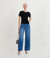 Top de manga corta ajustado al cuerpo, color marrón oscuro, con cuello redondo y bordes festoneados en color crema o beige claro.