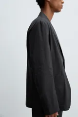 Blazer regular fit confeccionada en popelín de algodón. Presenta cuello con solapas de muesca, cierre frontal de un botón, bolsillo de vivo en el pecho y dos bolsillos de plastrón en la cadera. Diseño sin forro interior con abertura central en la espalda.