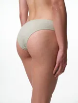 Bombacha tipo bikini de algodón con textura acanalada, tiro medio y detalle de puntilla en el borde superior.