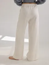 Pantalon de corte recto y tiro medio, confeccionado en lino, con cintura elastizada y tajos laterales en el ruedo.