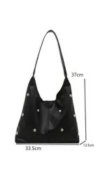 Cartera tipo hobo de cuero sintético negro, con diseño de tachas metálicas plateadas distribuidas por toda la superficie. Cuenta con una correa ancha integrada para llevar al hombro.