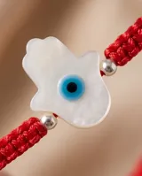 Pulsera de hilo rojo en macramé con dije central de Hamsa en nácar y plata 925, con terminaciones en esferas de plata.
