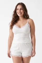 Conjunto de pijama de dos piezas de tejido rib color blanco, compuesto por una musculosa de tirantes finos con detalle de encaje en el escote y un short con detalles de encaje en el ruedo.