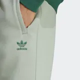 Pantalón de jogging verde claro, corte ajustado, con cintura elástica ajustable con cordón, bolsillos laterales y puños acanalados. Logo del trifolio bordado en la pierna. Confeccionado en tejido polar de algodón y poliéster reciclado.