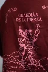 Remera oversize color bordó con cuello y puños de rib de color rosado. Estampado frontal en rosado con el texto "GUARDIÁN DE LA FUERZA" y otros símbolos.