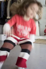 Pantalón tejido artesanalmente a rayas horizontales en tonos rojo, blanco, marrón y negro.