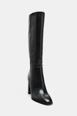Bota alta de piel color negro, con caña alta, detalles de pespuntes verticales y tacón alto en bloque.