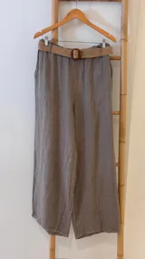 Pantalón gris de lino con corte ancho, cintura elástica y cinturón de rafia.