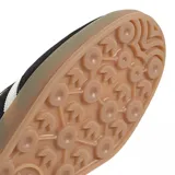 Championes Adidas Gazelle Indoor de diseño clásico, confeccionados en gamuza negra con las icónicas tres tiras laterales en blanco. Presentan el nombre del modelo en letras doradas, talón en contraste blanco y suela de goma color caramelo.