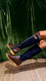 Botas altas combinadas de cuero y gamuza color marrón y azul marino, forradas en cuero y con cierre de bronce lateral.