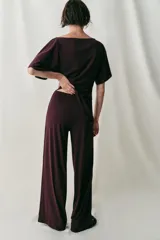 Pantalón largo color bordó, confeccionado en crepe fluido, con tiro alto, cintura elástica y diseño de pierna ancha.