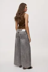Jean wide leg de tiro medio, con pierna amplia de caída recta, diseño de cinco bolsillos, pasacintos y cierre frontal con botón y cremallera.
