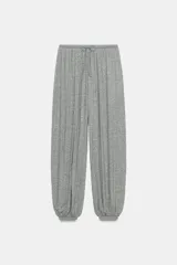 Pantalón bombacho confeccionado en mezcla de lyocell, color gris melange. Presenta tiro medio, cintura elástica con cordón de ajuste, pierna ancha y bajo abullonado con elástico.