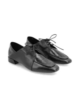 Zapato estilo oxford de cuero negro con diseño vanguardista, cordones y detalle en cuero con textura de reptil en la parte frontal. Cuenta con un tacón bajo cuadrado y suela laqueada.
