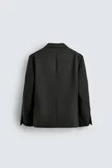 Blazer de corte relajado confeccionada en lana de origen italiano, con diseño de doble botonadura cruzada. Presenta cuello con solapas de muesca, manga larga con botones en puños, bolsillos con solapa en la cadera y abertura central en la espalda. Incluye forro interior a contraste.