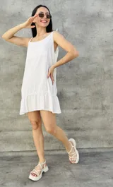 Vestido corto blanco de breteles finos con volados en el ruedo.