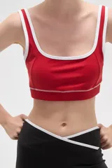 Top deportivo de poliamida color rojo, con escote cuadrado, breteles finos y detalles de ribete blanco en el cuello y bajo el busto.