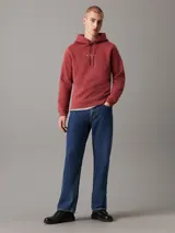 Buzo Calvin Klein de felpa color ladrillo, con capucha ajustable con cordón, puños y bajo acanalados, y logo bordado en el pecho.