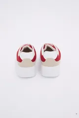 Zapatillas deportivas blancas con detalles en rojo y beige.
