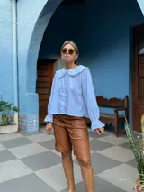 Bermuda de cuero sintético en color marrón, con diseño de corte recto, tiro medio y costuras verticales decorativas en el frente.