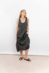 Vestido midi gris oscuro de lino, corte recto y sin mangas. Tiene bolsillos laterales y cuello redondo.