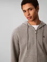 Buzo con capucha, cierre frontal completo y bolsillos tipo canguro dividido, de marca Calvin Klein.