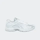 Championes Reebok Road Prime, color blanco con detalles en gris plateado. Presentan una parte superior de malla con paneles de tejido sintético y cuero, cierre con cordones, entresuela de EVA moldeada por inyección y suela de goma.