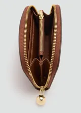 Billetera semicircular marrón con cierre de cremallera y tirador metálico esférico dorado, con el logo de la marca estampado en el frente.