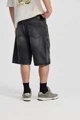 Bermuda de jean estilo baggy, color azul oscuro, con silueta amplia y largo por debajo de la rodilla, confeccionada en 100% algodón.