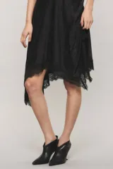 Vestido midi asimétrico de satén jacquard negro con escote lencero, breteles finos regulables, falda amplia con movimiento y terminación de puntilla en el ruedo.