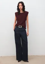 Blusa de color bordó con cuello barco, manga corta y hombreras marcadas que aportan estructura. Presenta un diseño recto y limpio con detalle de fruncido en los hombros.