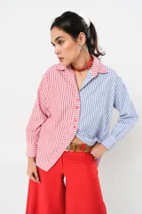 Camisa a rayas rojas y blancas en un lado y azules y blancas en el otro, con corte en A y abertura central con botonadura doble.