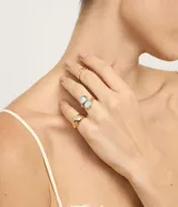 Set de tres anillos de metal reciclado con baño light gold. Incluye un anillo bold, uno con resina de forma geométrica y uno trenzado.