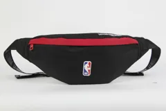 Riñonera negra de nylon con detalles en rojo y logo de la NBA en el frente.