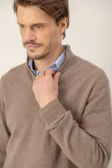 Sweater de lana lambswool color beige, con diseño de medio cierre frontal y cuello alto.