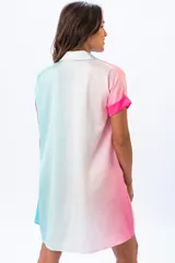 Vestido camisero corto, con diseño color block en rosa y celeste. Tiene cuello camisero, mangas cortas con puños y cierre frontal con botones.
