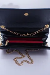 Cartera tipo sobre color beige con textura granulada y correa de cadena dorada.