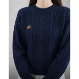 Buzo de punto color azul marino, con cuello redondo y diseño trenzado, de manga larga y calce cómodo.