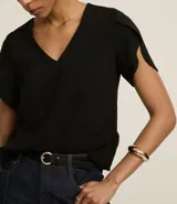 Blusa color beige de poliéster con efecto arrugado (airflow), escote en pico y mangas cortas tulipán (cruzadas).