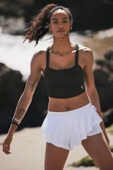 Top deportivo ajustado color negro, con escote redondo al frente y espalda cruzada.