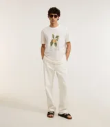 Remera de algodón color crudo con estampa de dibujo de durazno con hojas y texto.