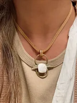 Collar con colgante de bronce con detalle de nácar blanco.