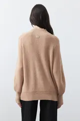 Polera de tejido de punto en color marrón oscuro, con cuello alto y diseño de silueta relajada.