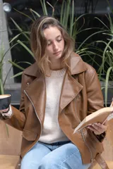 Chaqueta negra de eco-cuero, corte recto y oversize, con solapas amplias, múltiples bolsillos y cierres en las mangas.
