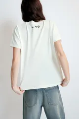 Remera de algodón de corte regular con cuello redondo y manga corta. Presenta un estampado frontal con un dibujo lineal de un rostro y la firma de Henri Matisse en color azul.